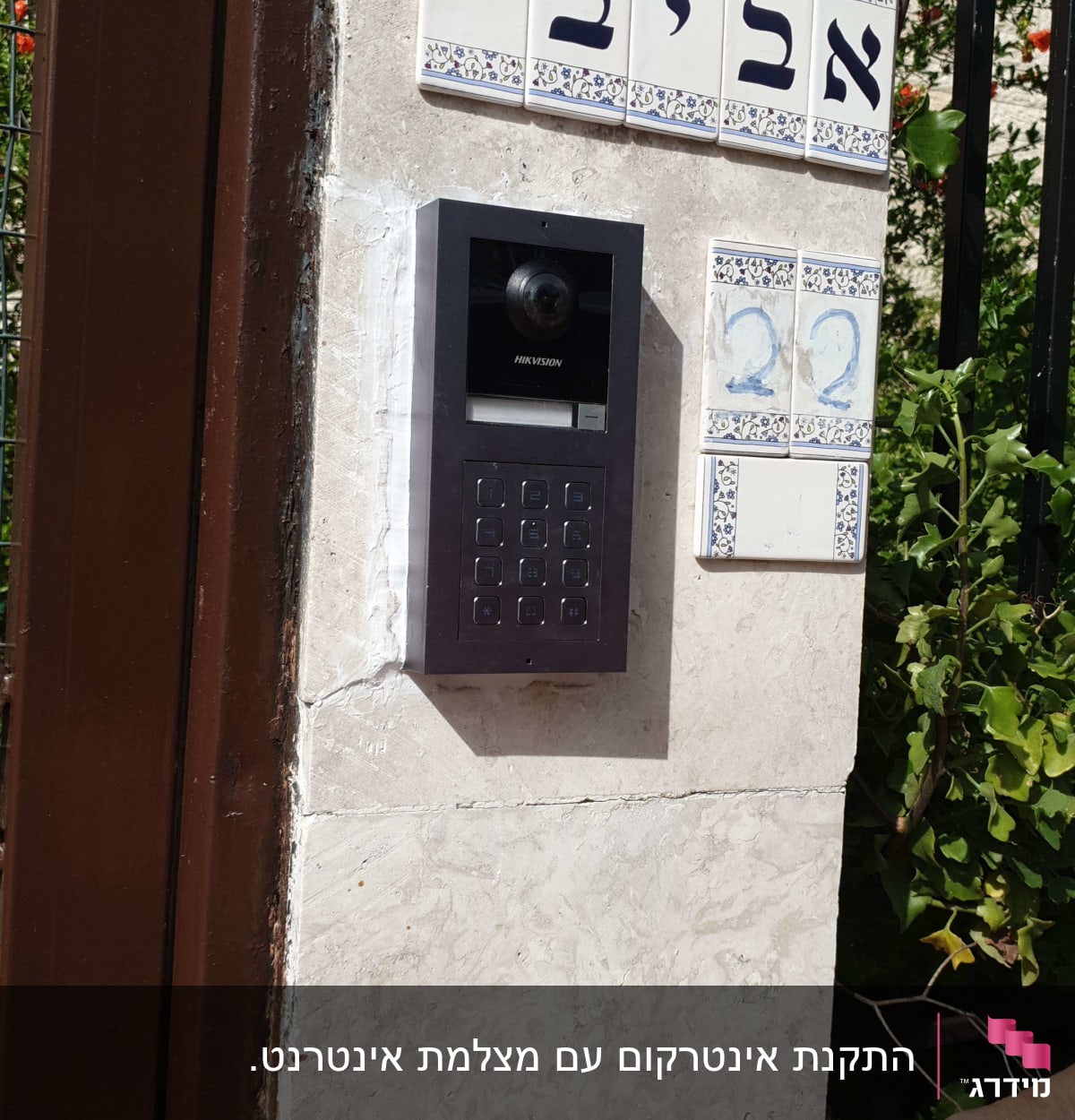 אינטרקום עם מצלמה ולוח מקשים על קיר